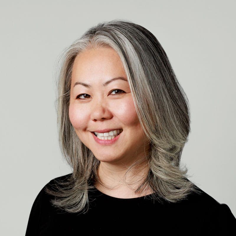  A woman wearing a black shirt smiles at the camera.