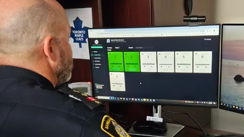 A police officer sits in front of a computer screen.