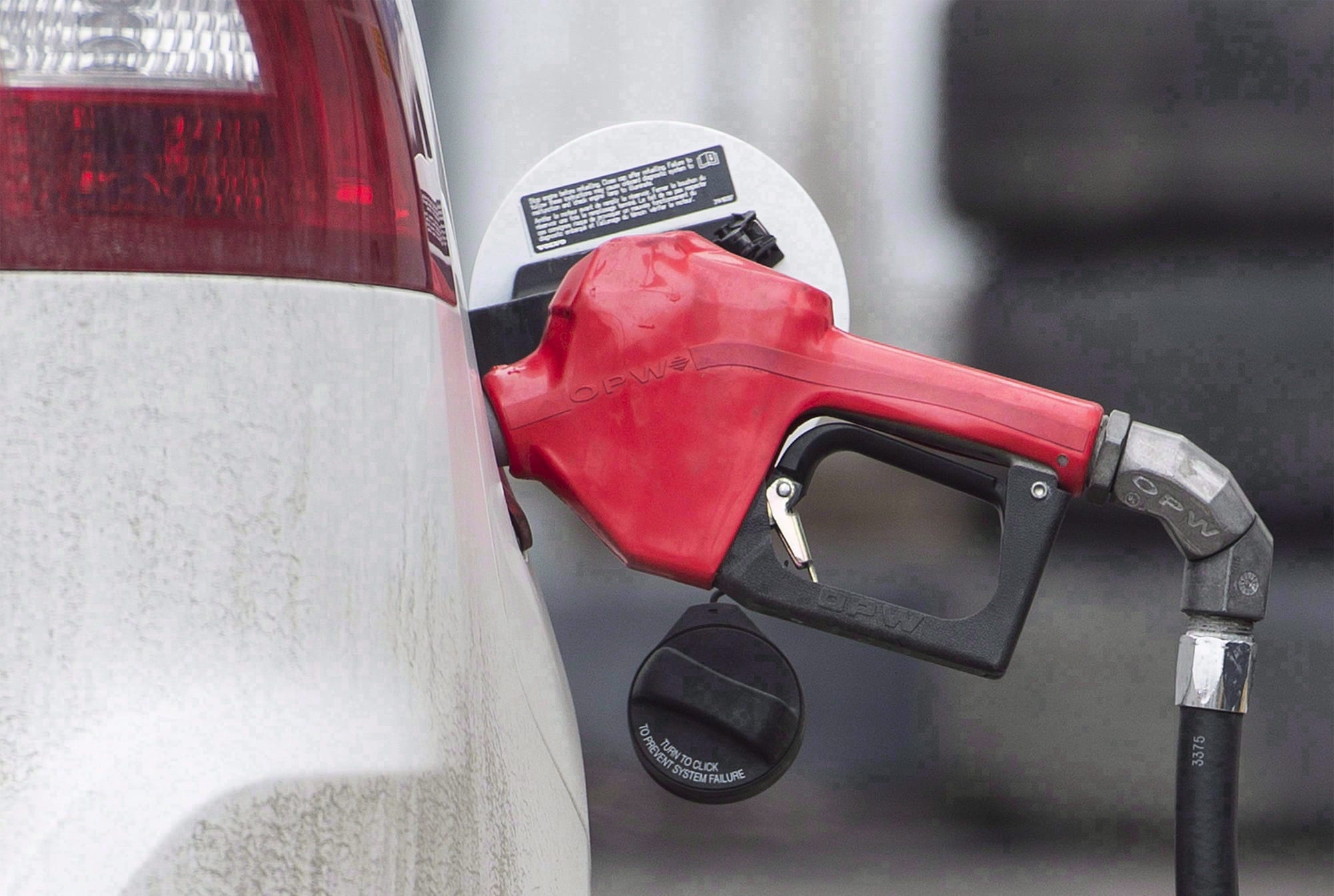 A car is shown fuelling up at a gas station.