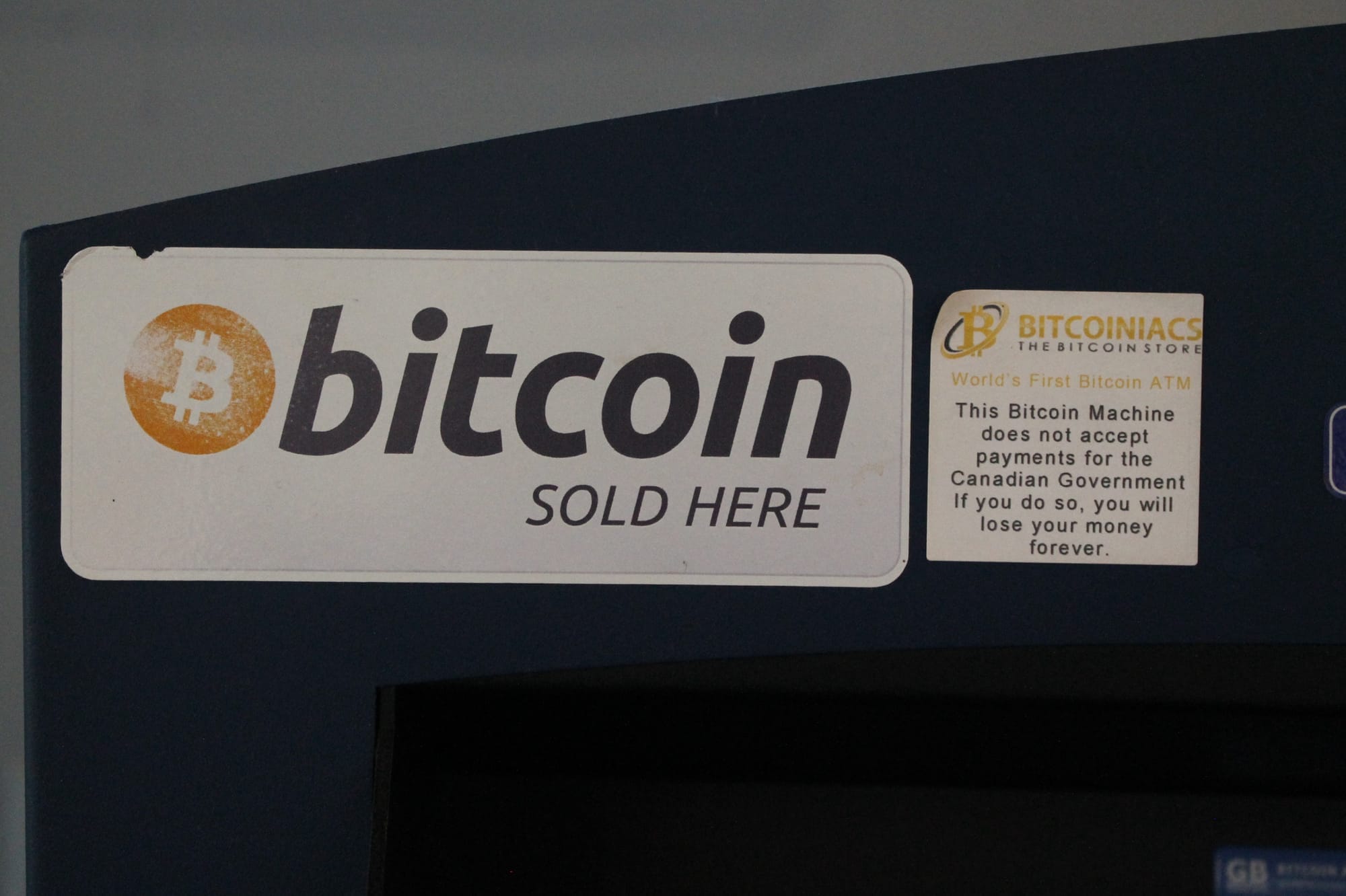 A sticker on a bitcoin ATM warns that it does not accept payments for the Canadian government.