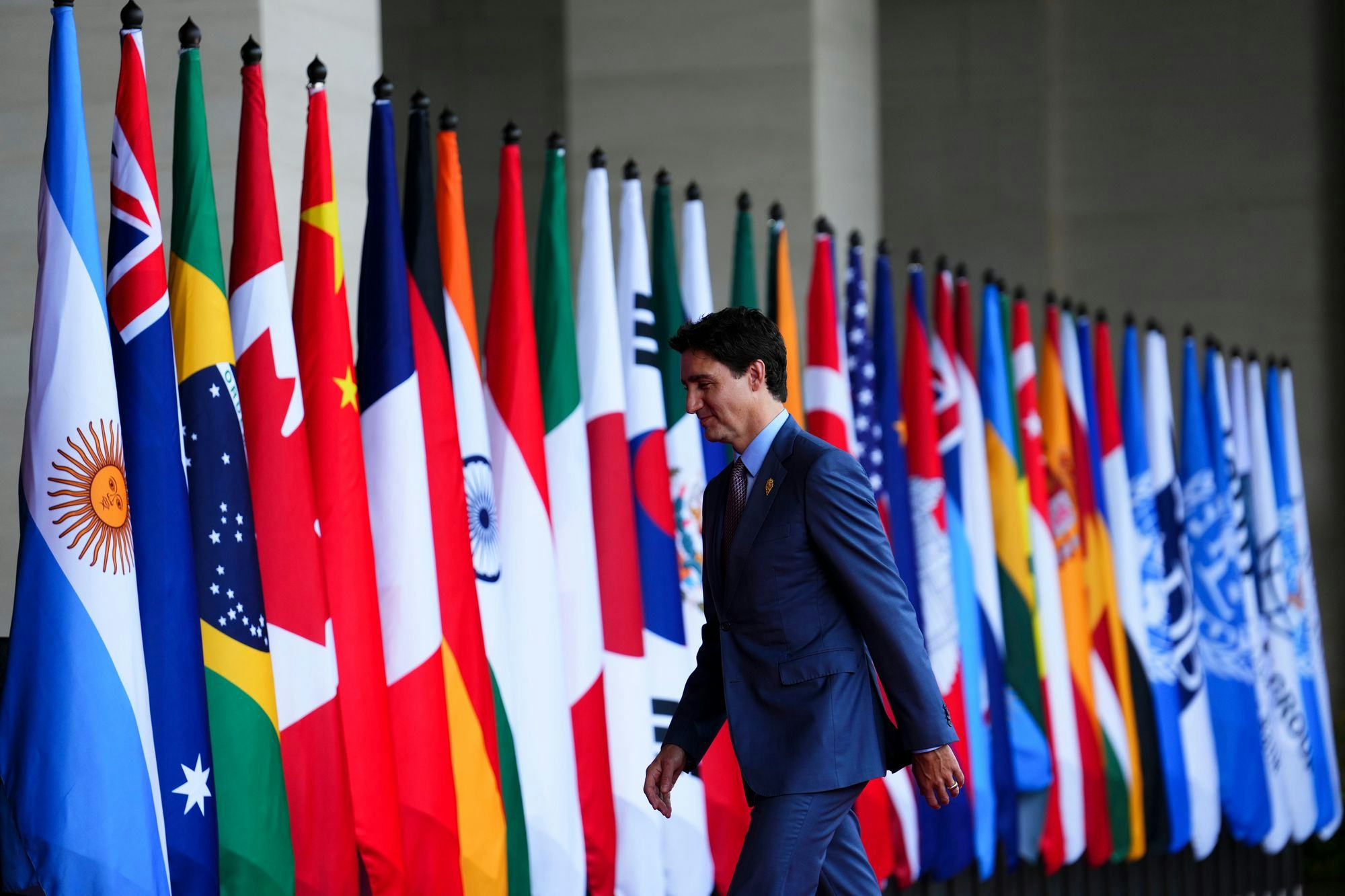Photo of Justin Trudeau in front of several countries' flags at the 2022 G20 summit. The Canadian Press/Sean Kilpatrick.