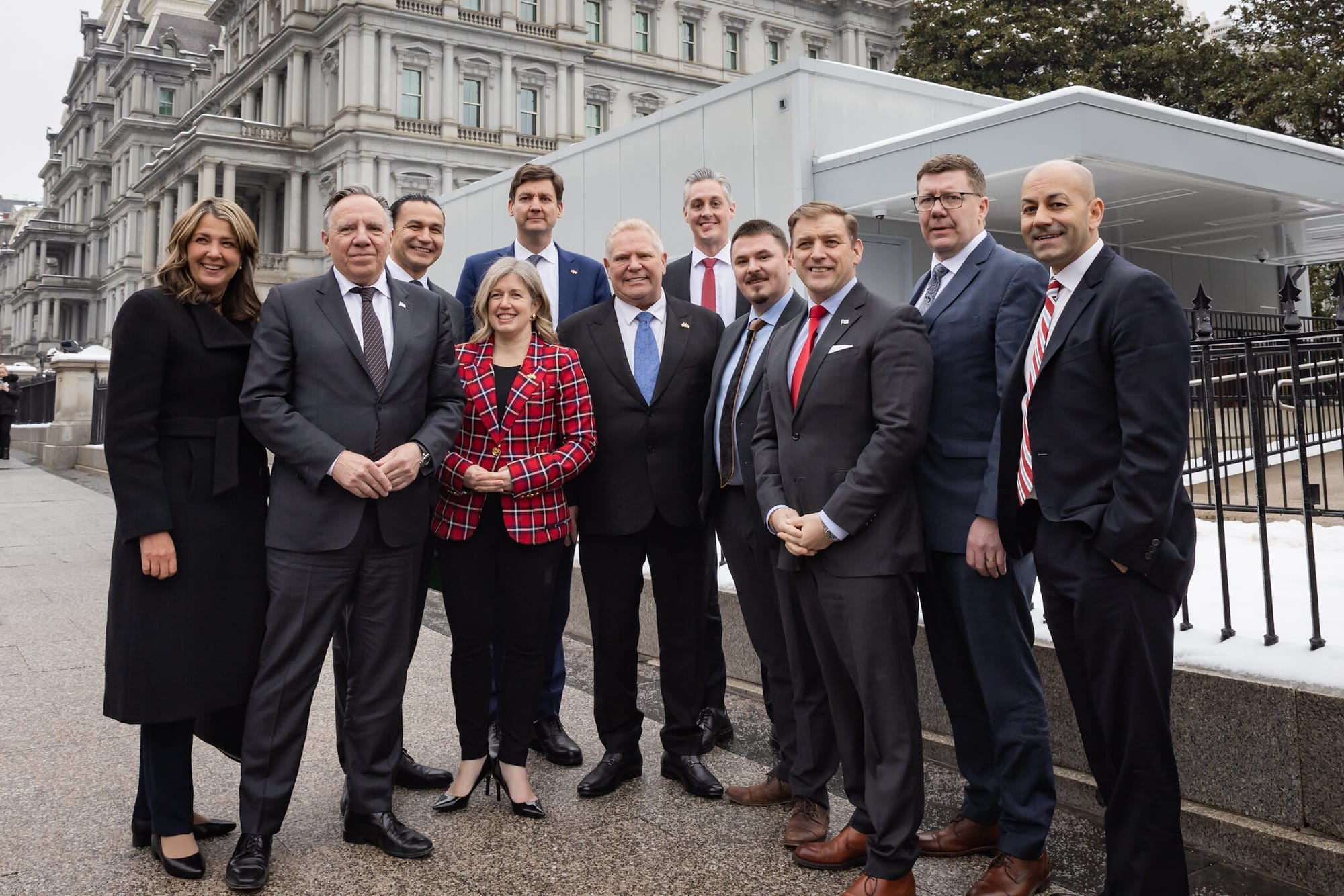 The 13 premiers pose for a photo outdoors in Washington, D.C.