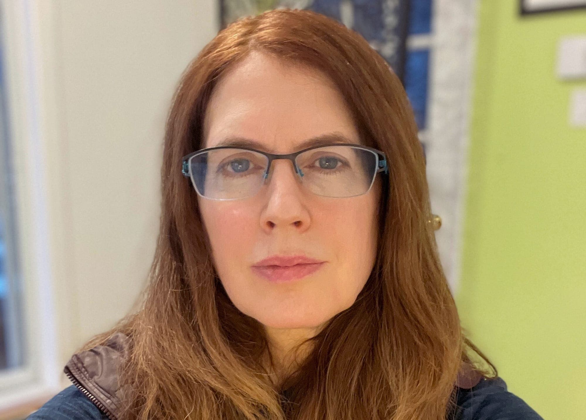 Patti Sonntag is shown from the shoulders up. She has long brown hair and glasses.