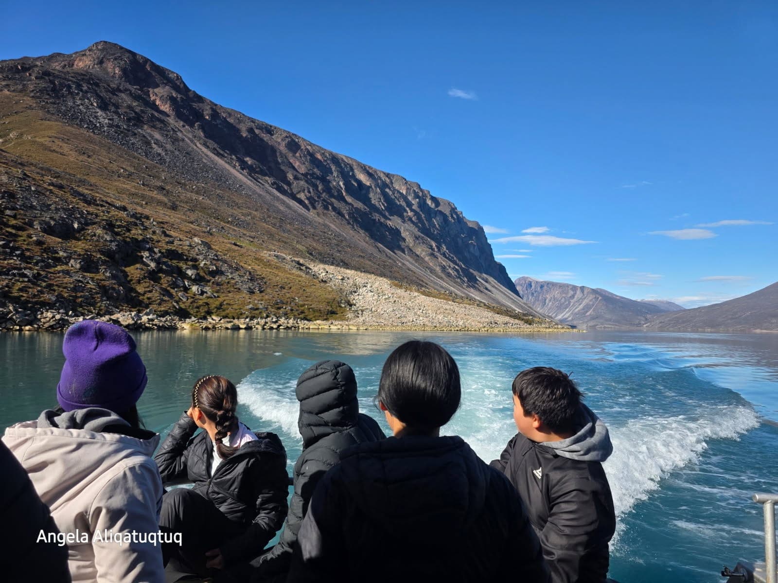 Students look at fjords on a boat trip from Qikiqtarjuaq to Auyuittuq National Park in Nunavut.