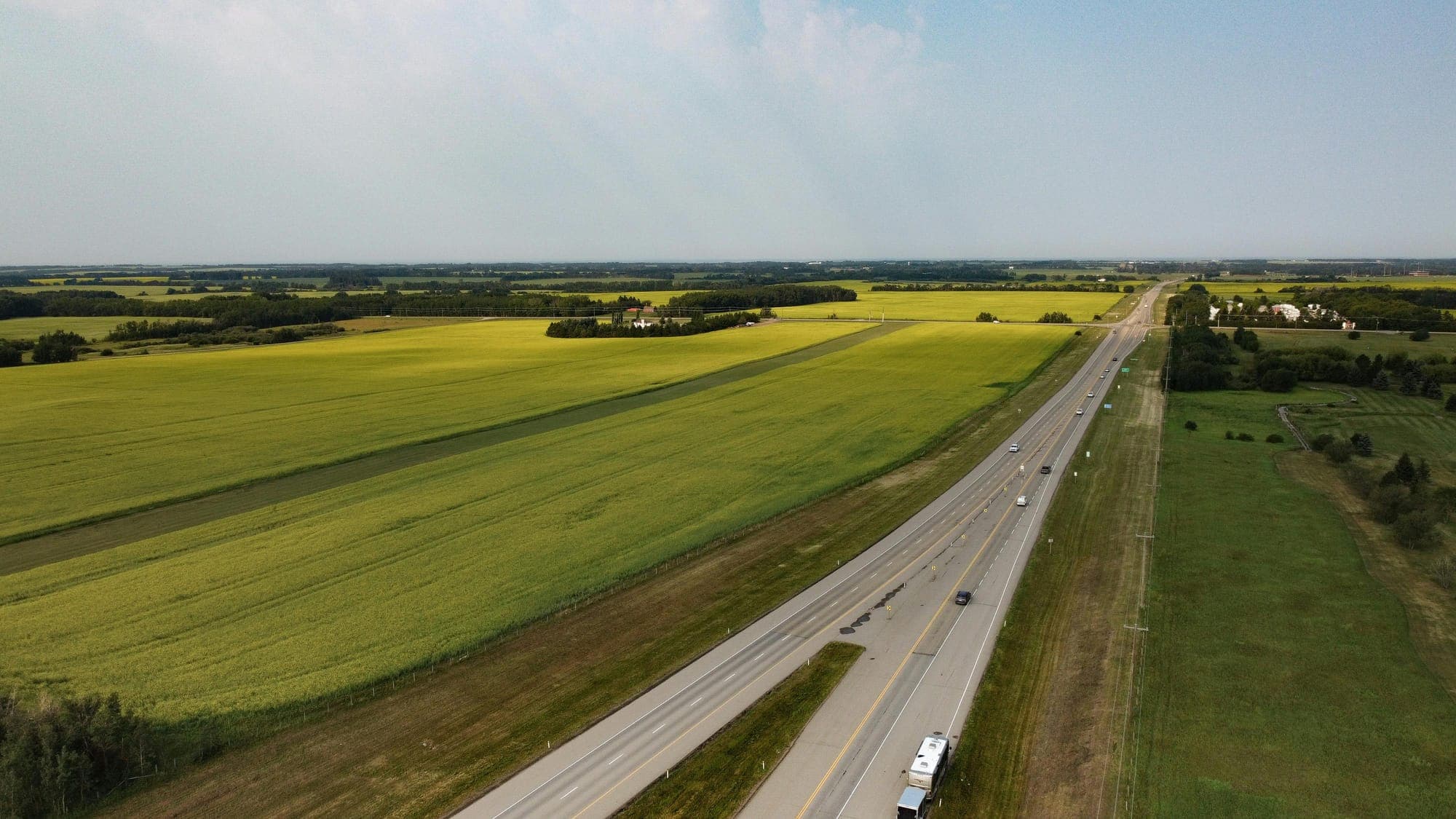 An aerial view of farmland and a highway.