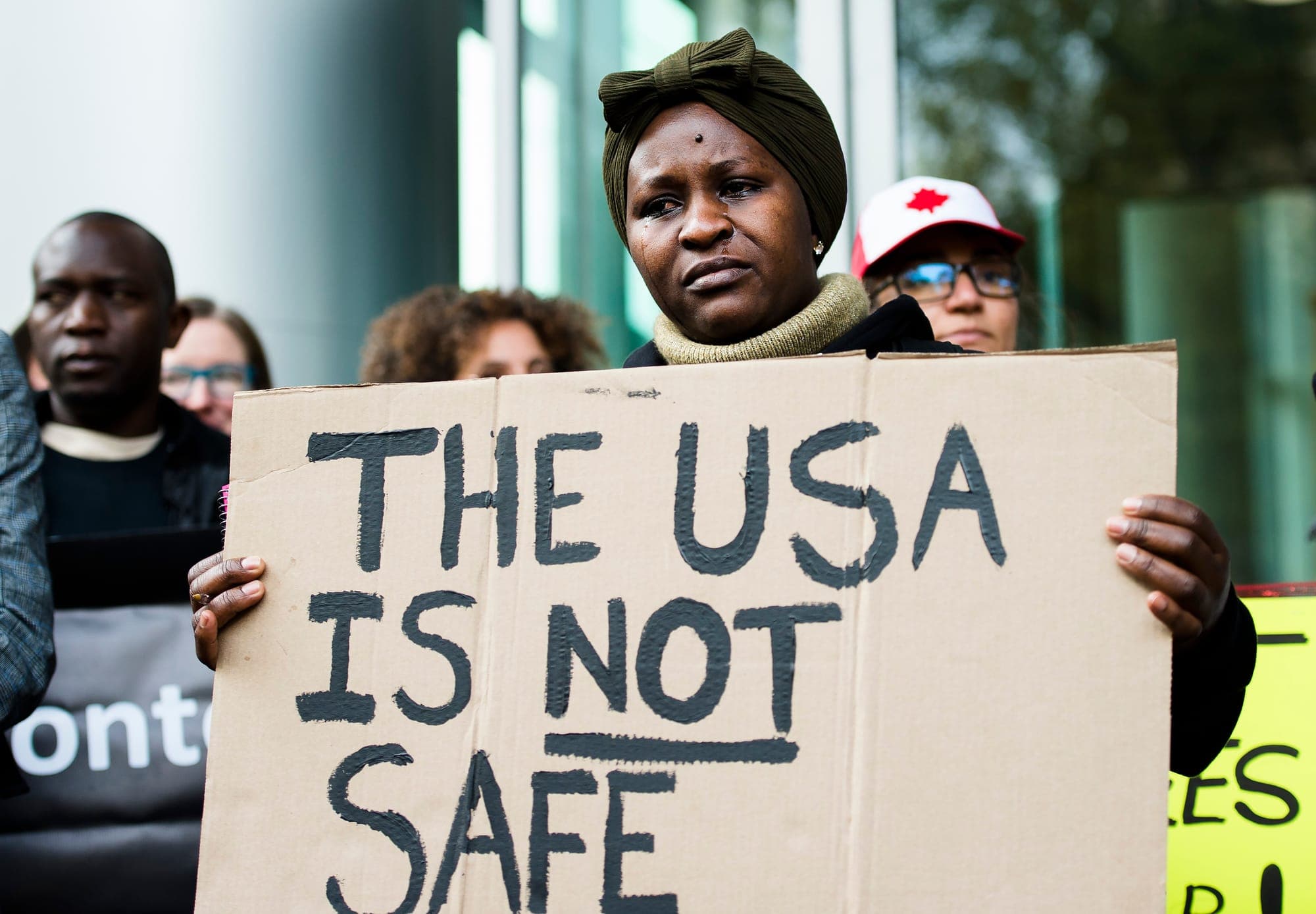 Kikome Afisa holds a sign as she along with others protest outside the Federal Court of Canada building in Toronto.