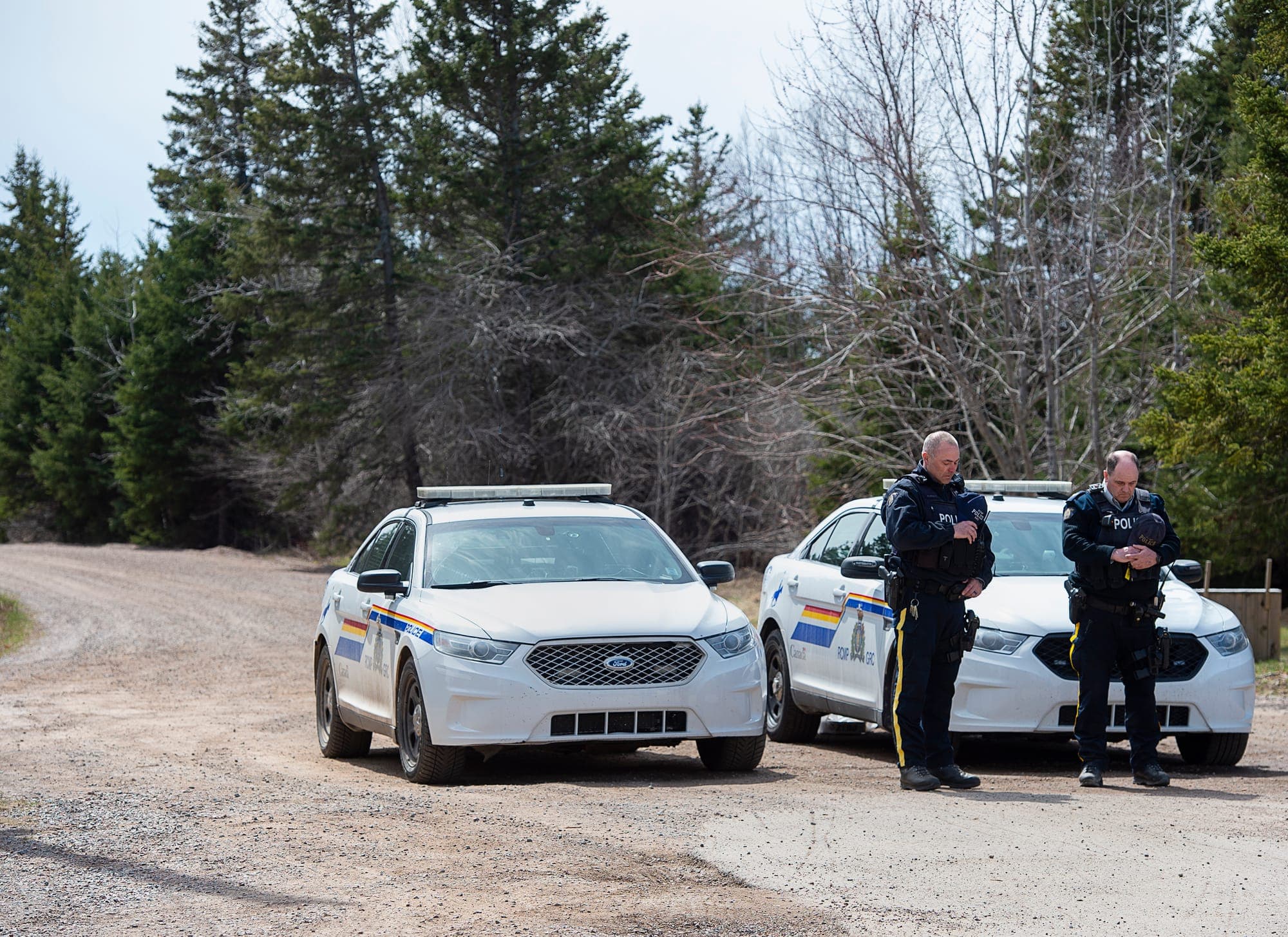 Two RCMP officers observe a moment of silence to honour slain Const. Heidi Stevenson and the other 21 victims of the mass killings that started in Portapique, N.S., in April 2020.