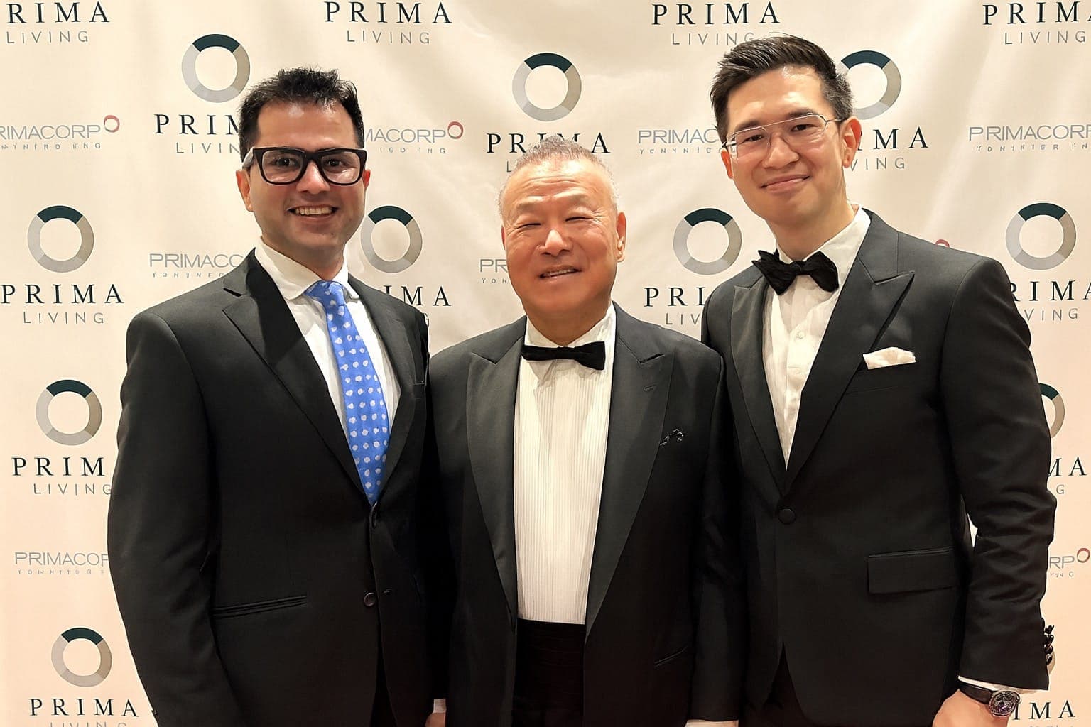 Peter Chung stands with two colleagues at a Primacorp event. All three men are wearing suits and ties.