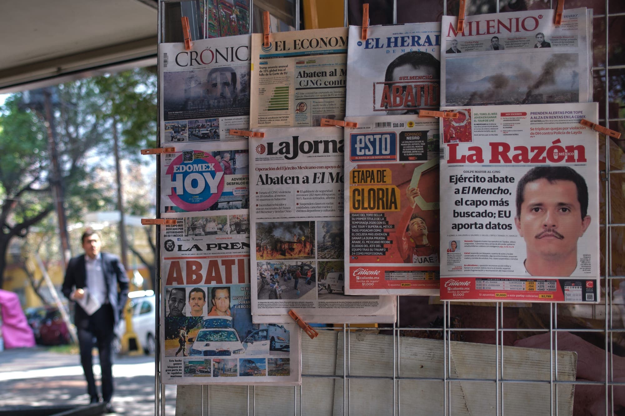 Newspapers hang on display for sale in Mexico City on Feb. 23, a day after the Mexican army killed El Mencho.