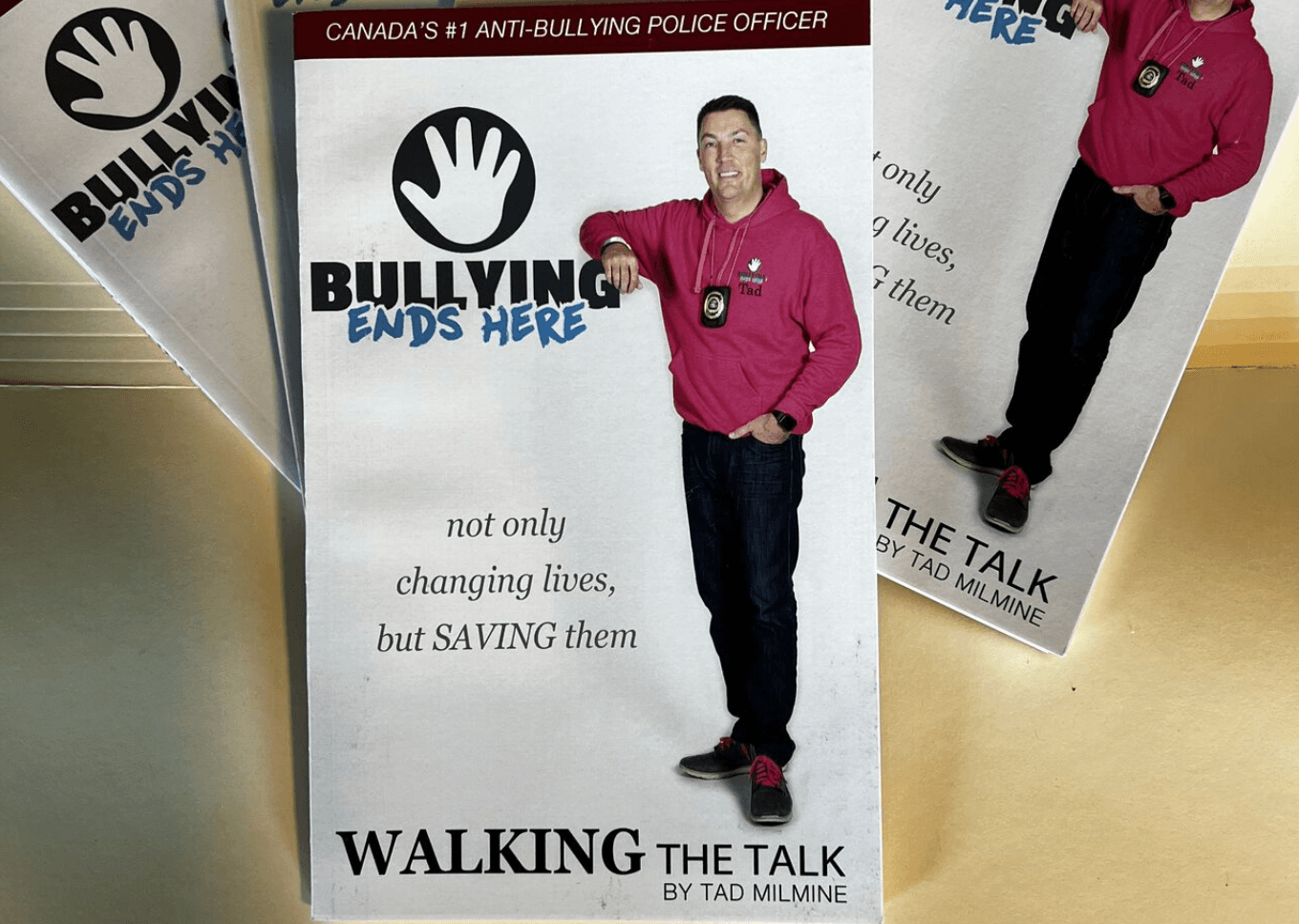 A brochure for charity Bullying Ends Here shows Tad Milmine in a pink hoodie and with his police badge around his neck.