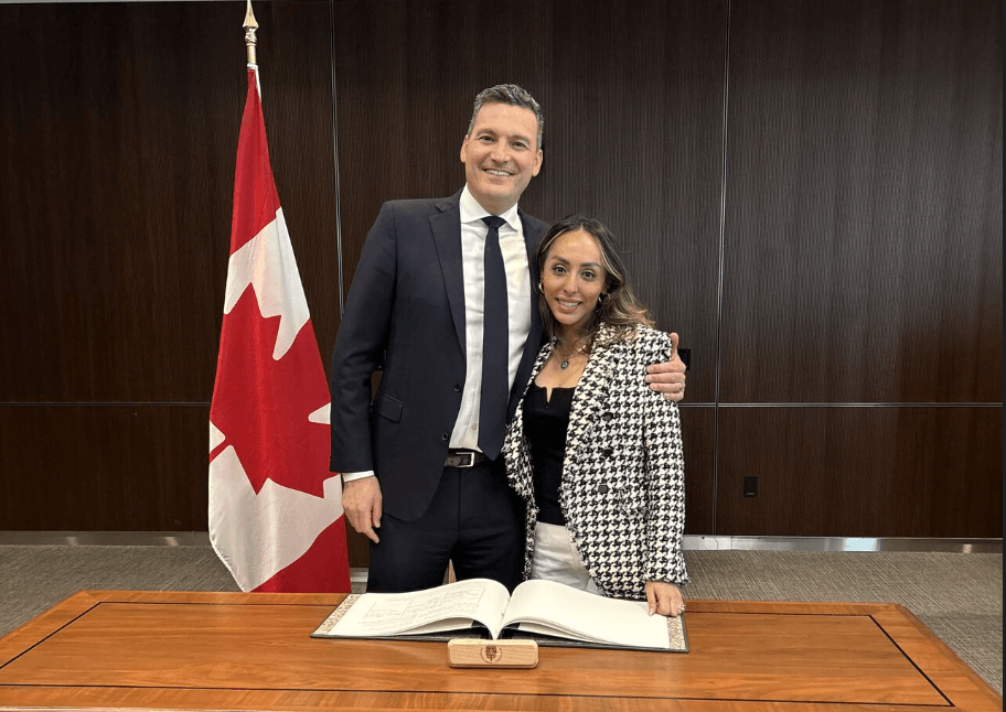 Evan Solomon poses for a photo with his arm around Sharan Kaur in Ottawa.