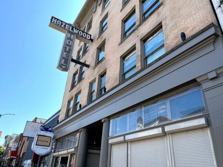 The Hazelwood Hotel sign is displayed on the side of a yellow brick building.
