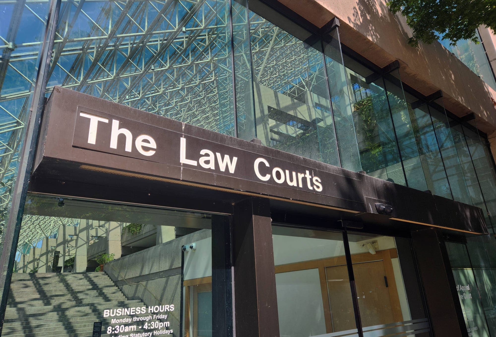 A sign reading 'The Law Courts' is displayed over an entrance to the B.C. Supreme Court in Vancouver.