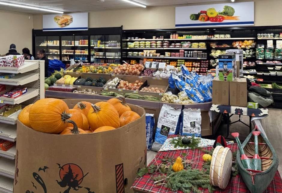 The produce section of a grocery store, with three shoppers browsing.