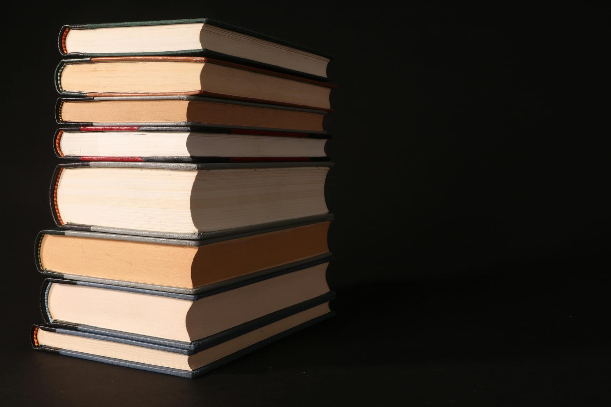 A stack of books against a black background.