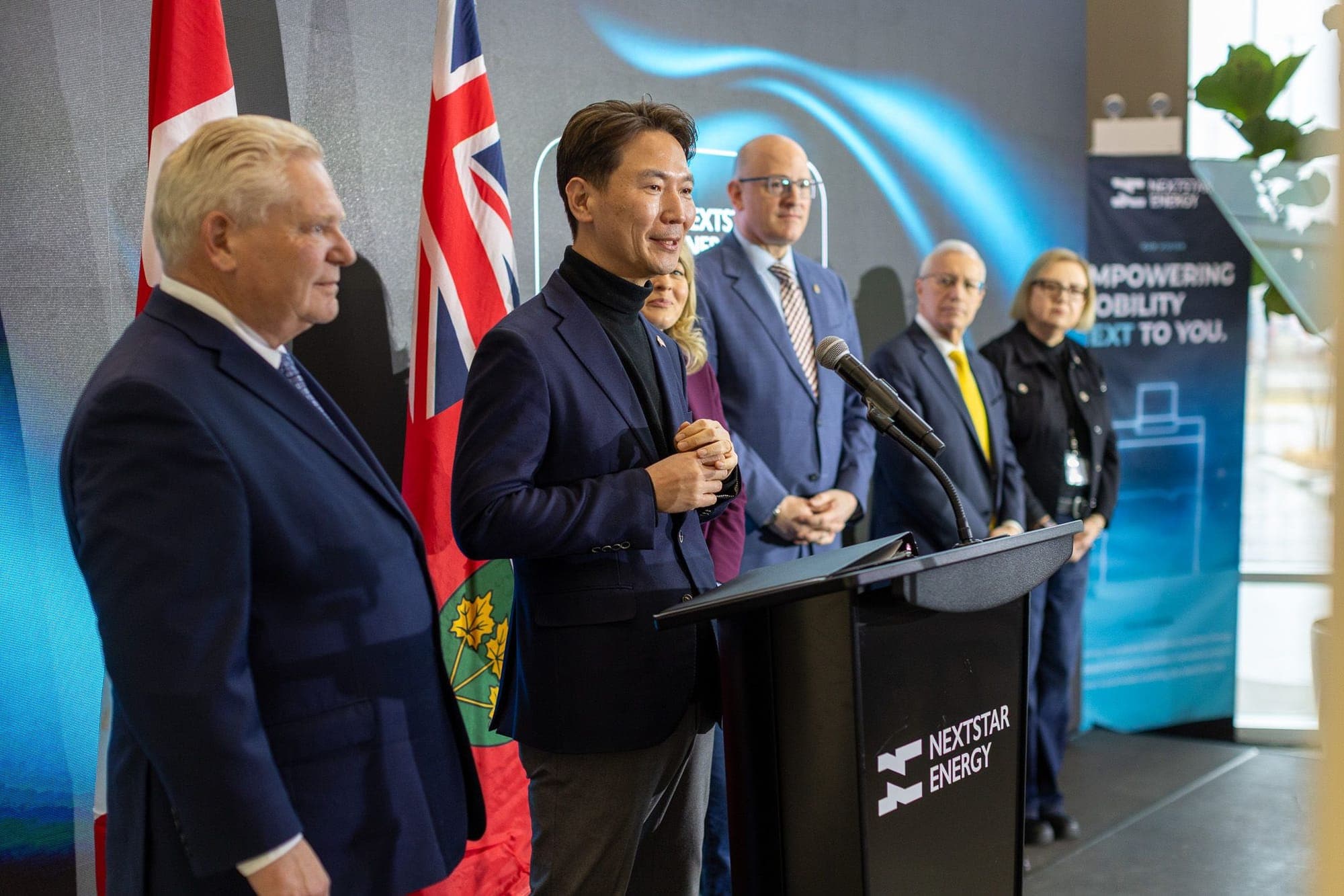 An executive stands next to Ontario Premier Doug Ford and federal Industry Minister Mélanie Joly at the NextStar Energy facility's grand opening.