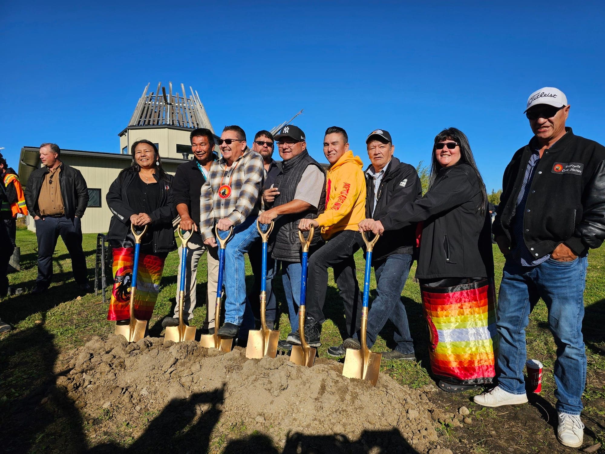 Members of Driftpile Cree Nation pose while holding shovels at a groundbreaking ceremony for a community health centre.