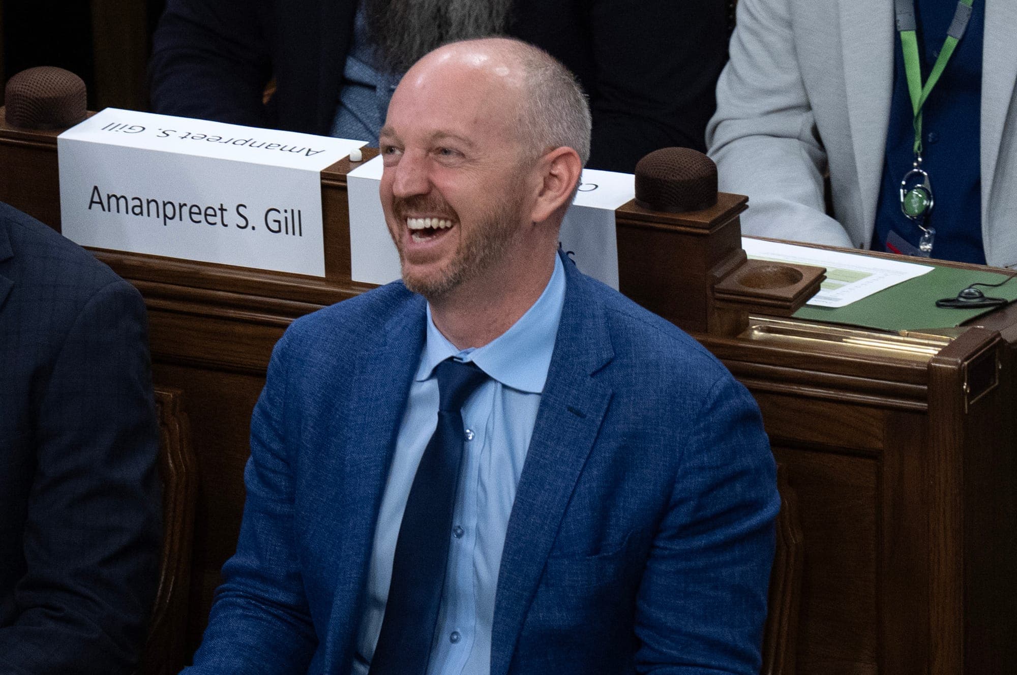 Michael Guglielmin is pictured sitting in the House of Commons wearing a blue suit.