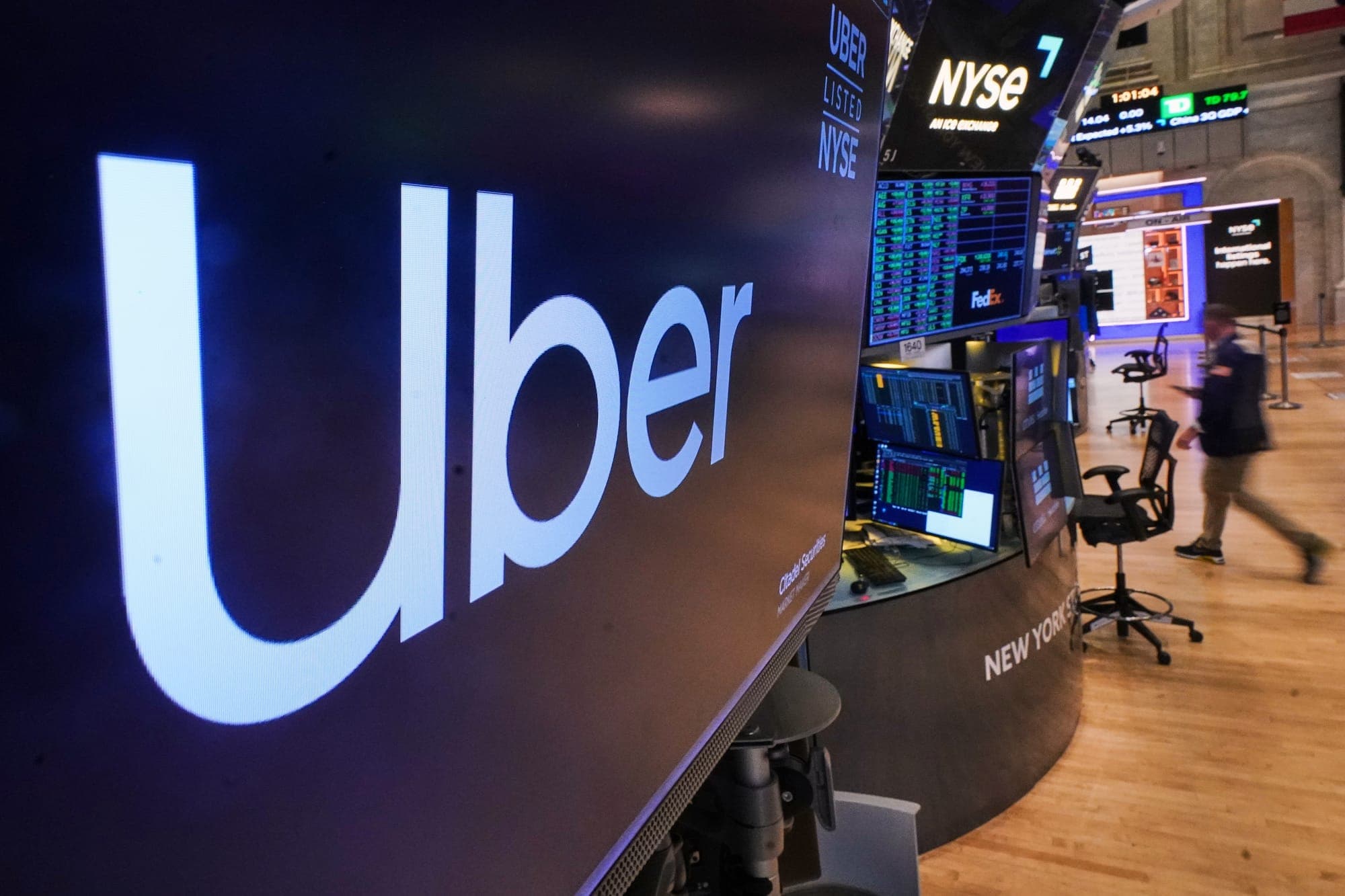 The logo for Uber is displayed above a trading post on the floor of the New York Stock Exchange, Monday, Oct. 20, 2025.