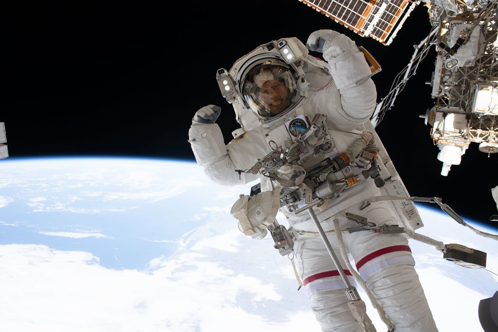 An astronaut is seen in space, above the Earth and photographed from the International Space Station.