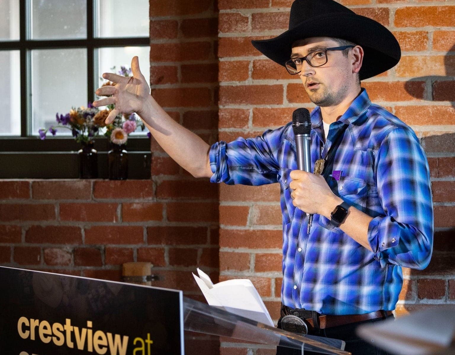 Crestview vice-president Evan Menzies wears a plaid shirt and cowboy hat while he speaks at an event during the Calgary Stampede.