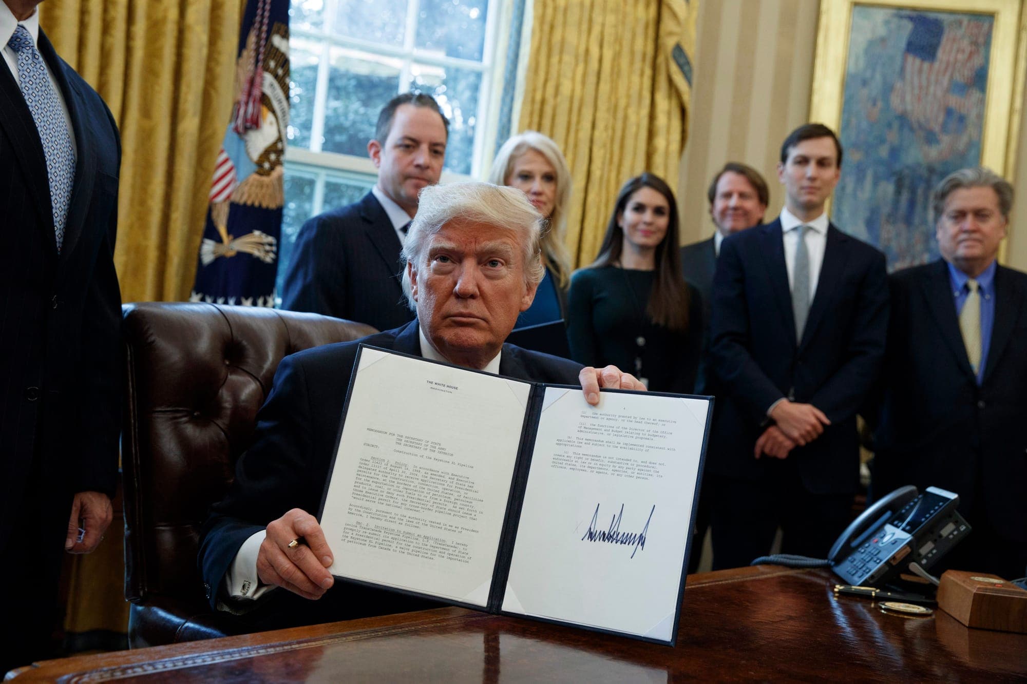 President Donald Trump shows his signature on an executive order on the Keystone XL pipeline Jan. 24, 2017, in the Oval Office of the White House in Washington.