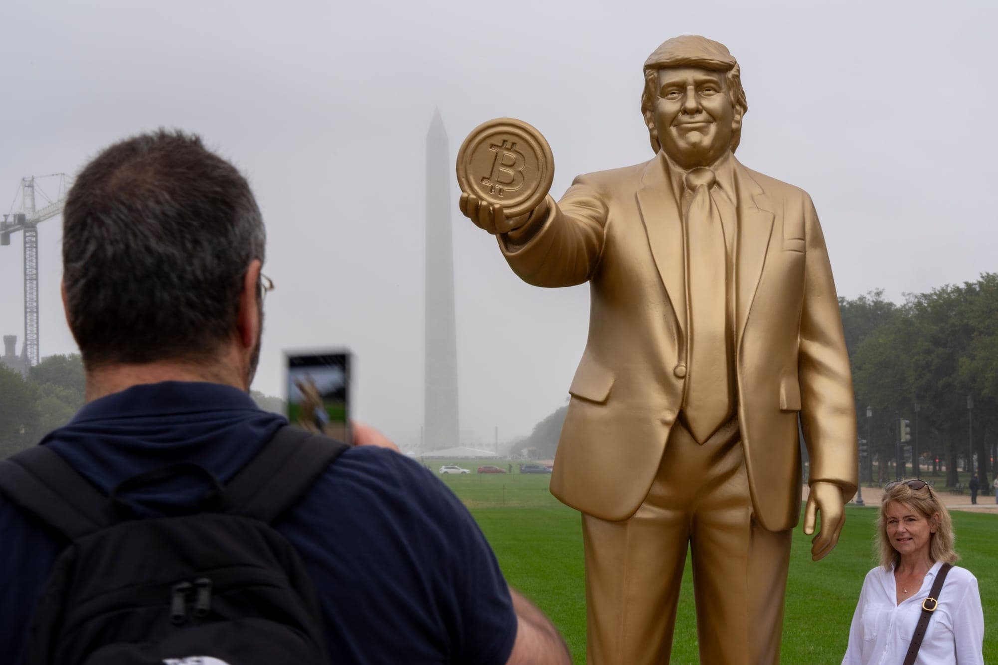 A large golden statue of Donald Trump holding the Bitcoin logo is pictured on the National Mall in Washington, D.C.