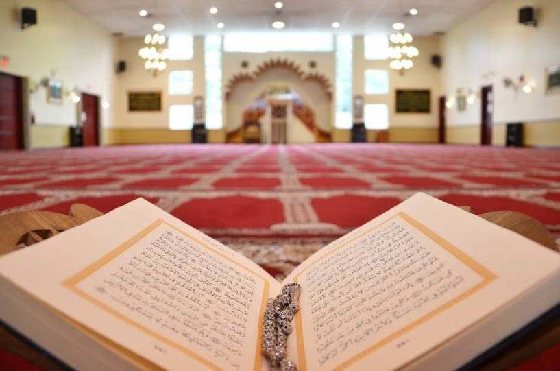 An open Quran is pictured on a red carpet inside a mosque.