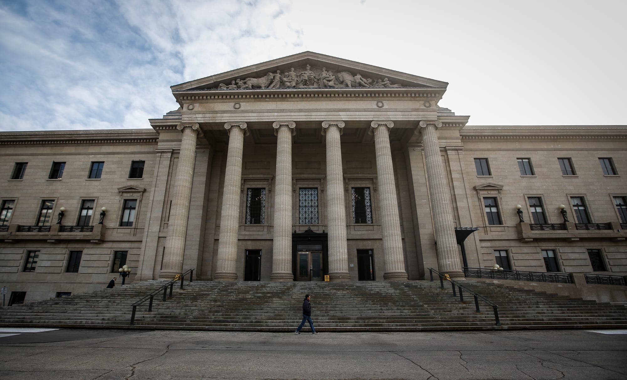An exterior photo of the Manitoba Legislative Building on a cloudy day.
